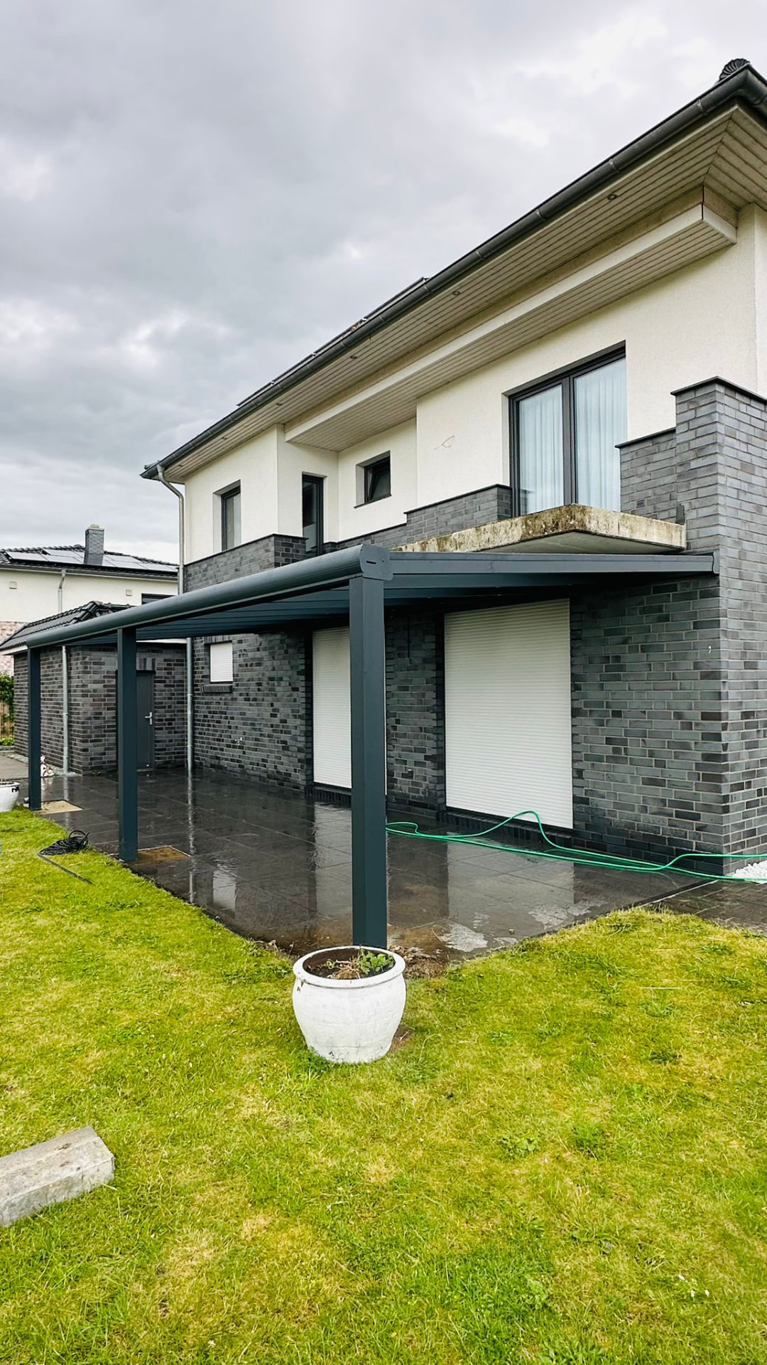 Schmale Terrassenüberdachung aus Aluminium entlang der Hausfassade