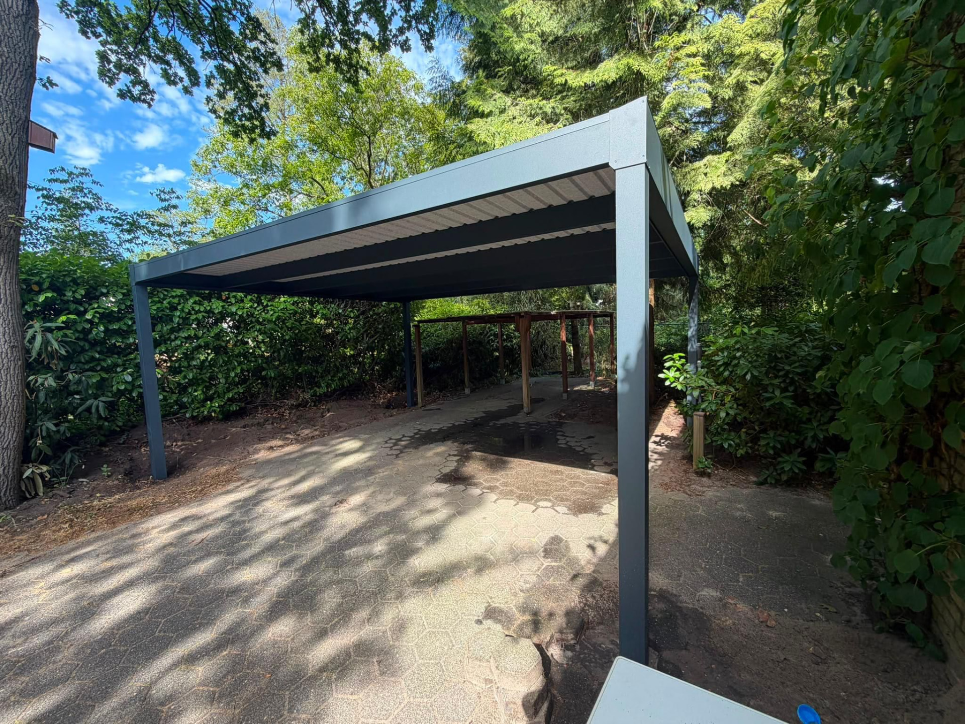 Freistehendes Doppelcarport aus Aluminium in einer Einfahrt