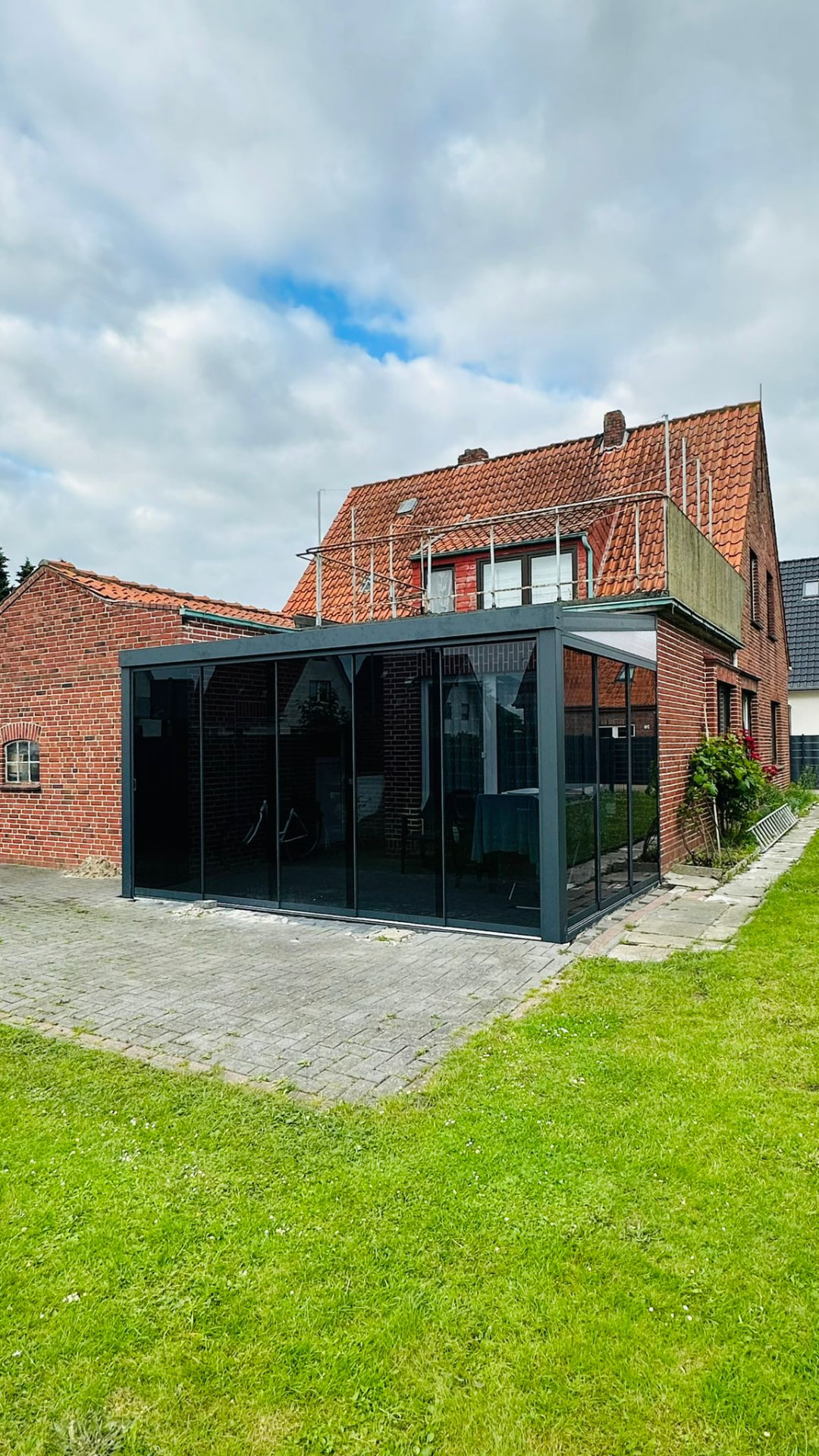 Terrassenüberdachung mit Verglasung an einem Backsteinhaus