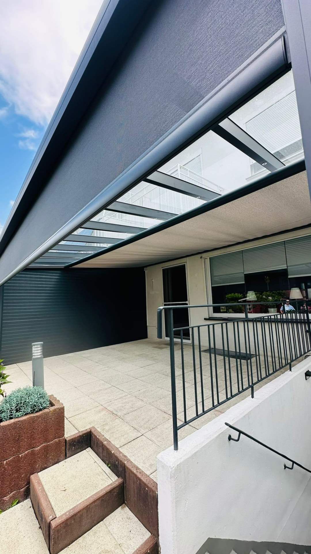 Senkrechtmarkise als Sonnenschutz an einer Terrassenüberdachung mit Glasdach
