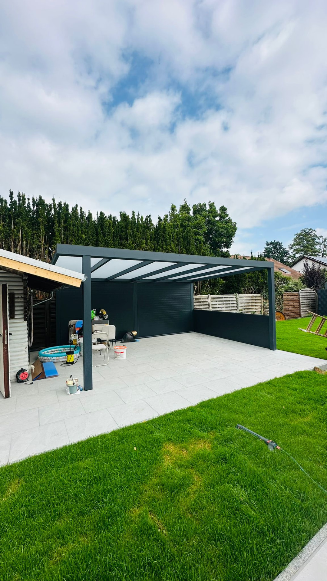 Freistehende Terrassenüberdachung aus Aluminium mit Glasdach im Garten
